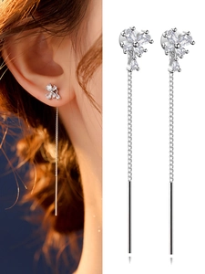 Detail of silver long tassel earrings with sparkling clover leaf studs for women