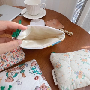 Close-up showing internal capacity of floral quilted cotton pouch with zipper closure