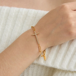 Gouden roestvrijstalen paperclip armband met een kruishanger van pavé kristallen