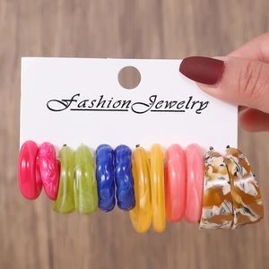 Gros plan de 6 paires de boucles d'oreilles créoles en résine acrylique colorée