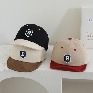Three minimalist soft brim baby baseball caps with B embroidery on a white display stand