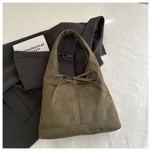Close-up of olive green suede tote bag on white texture with professional styling