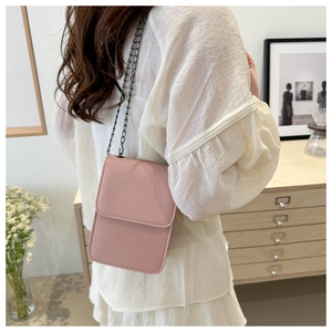 Close-up of pink chain crossbody bag showing fine stitching and smooth leather texture