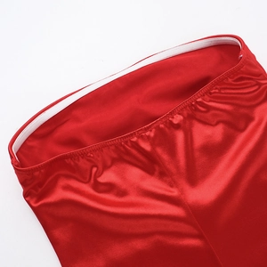 Detail of red satin dress featuring smooth glossy texture and precise stitching detail