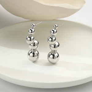 Macro detail of silver gradient sphere earrings with five polished beads in cascading sizes