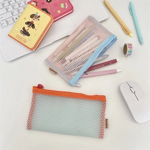Detailed top view of large mesh stationery pouches with colorful contrasting zippers on a desk