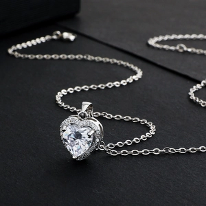 Vue macro d'un collier pendentif cœur en zircon avec pierres fines sur fond noir texturé