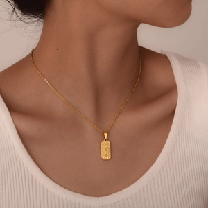 Gold pendant necklace featuring mystic sun, moon, and star relief on a slim chain