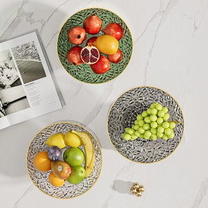 Close-up of glass fruit bowls with diamond facets and gold rims on marble table