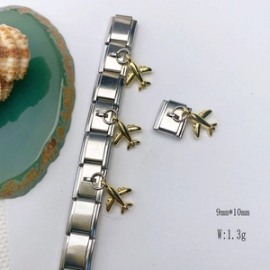 Detailed macro view of a gold plane charm on a silver stainless steel bracelet link