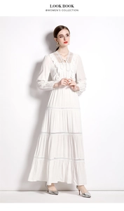 Detail eines weißen Boho-Maxikleides mit Spitzeneinsätzen und Stufenvolants