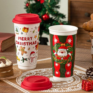 Festive Santa and Gingerbread Man ceramic mugs with red silicone lids in holiday setting