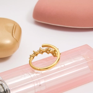 Close-up of a gold adjustable ring with clear zircons on a pink lipstick tube