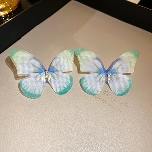 Détail de pinces à cheveux papillon dégradé bleu-vert avec de petits strass brillants