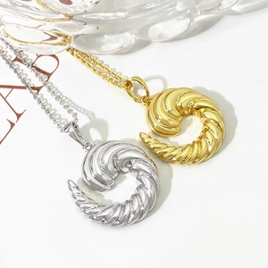 Detailed view of gold and silver twisted horn pendant necklaces with sleek metal texture