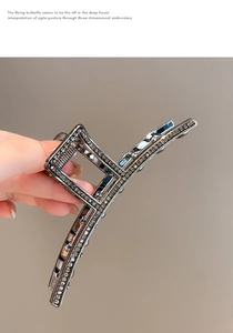 Close-up of gunmetal shark hair clip with sparkling rhinestones and hollow design