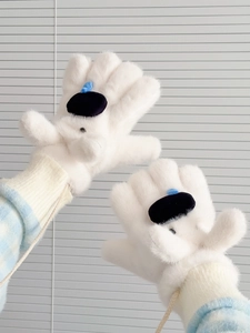 Détail de moufles blanches en fausse fourrure avec cordon et décoration de dessin
