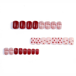 Short square press-on nails with red and pink heart patterns for Valentine's Day
