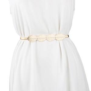 Detailed close-up of golden leaf-designed metal elastic belt on a white dress
