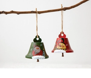 Macro view of hand-painted iron Santa and Snowman bells hanging from rustic wood