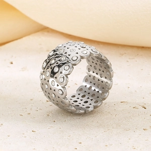 Detail of silver titanium steel ring with sparkling crystals on a textured stone base