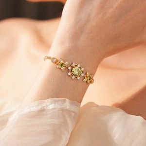 Détail d'un bracelet vintage en or avec zircon jaune ovale et motifs papillons sur le poignet