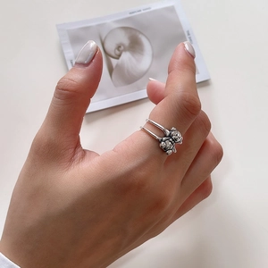 Detail of 925 sterling silver ring with double layer band and vintage bear charms