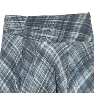 Detail of the blue plaid asymmetric midi skirt showing waist pleats and fabric texture