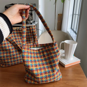 Detail of retro knit tote bag set featuring orange, blue, and yellow plaid texture