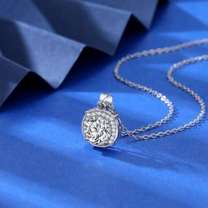 Macro detail of 2 carat zircon pendant with halo setting on blue textured background