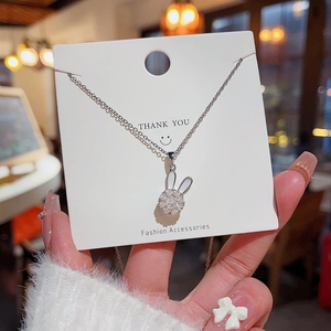 Detail of a rotating rabbit necklace pendant with sparkling zircons and white inlay