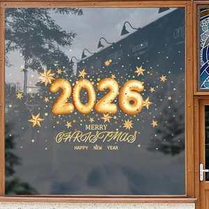 Golden 2026 Christmas window decals with stars and holiday greetings on dark glass