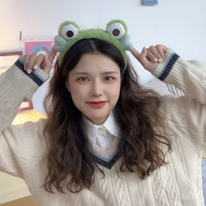 Cute green plush frog eye headband for face washing with soft cartoon design on a model