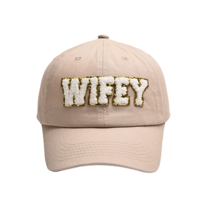 Detailed close-up of WIFEY fuzzy letter embroidery with gold glitter border on beige cap