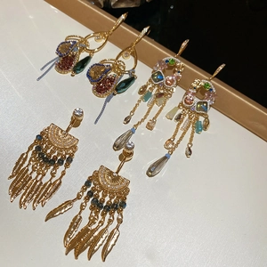 Detail of vintage French crystal tassel earrings with gold feathers and colorful stones