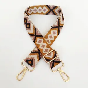 Macro detail of geometric diamond jacquard strap with gold-tone swivel lobster clasps