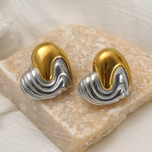 Two-tone heart stud earrings in gold and silver with liquid metal texture on stone