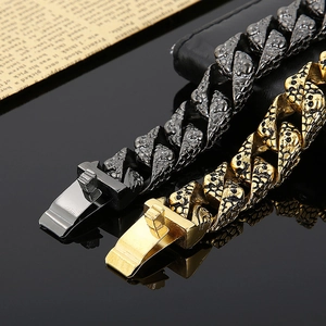 Detail of hip hop skull pattern cuban chain bracelet in black and gold metal finish