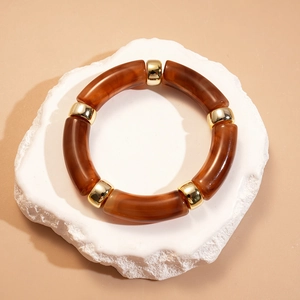 Détails des segments en acrylique ambré et perles dorées sur bracelet géométrique