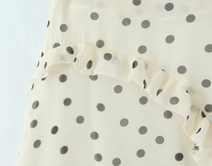 Detailaufnahme von beigem Chiffonstoff mit Polka-Dots und eleganten Rüschennähten