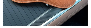 Close-up of orange litchi grain leather glasses case with white stitching detail