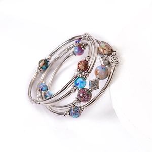 Detail of bohemian multilayer wrap bracelet featuring imperial stone beads and silver metal