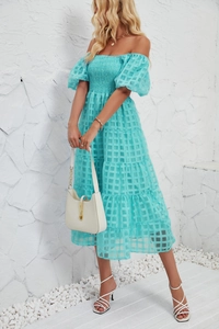Detail of smocked bodice and puff sleeves on a mint green flowy tiered beach dress