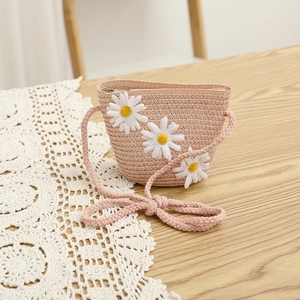 Detail of pink straw crossbody bag with white daisies and secure zipper closure