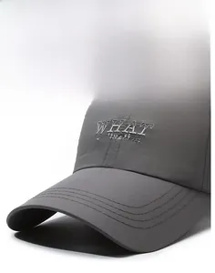 Gros plan sur la casquette grise avec broderie WHAT a situation et bordure surpiquée