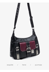 Detail view of the multi-pocket saddle bag with burgundy flap and pebbled leather texture
