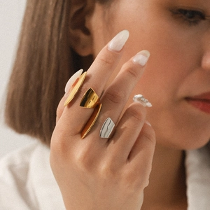 Close-up of minimalist geometric stainless steel rings in gold and silver finish on hand