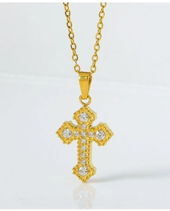 Macro detail of gold cross pendant with eleven sparkling white cubic zirconia stones