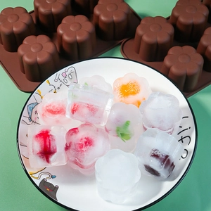 Macro detail of a 6-cavity flower silicone mold with fruit-filled jelly and ice cubes