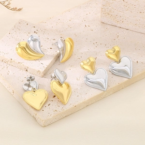 Ensemble de boucles d'oreilles cœur en or et argent sur fond de pierre naturelle